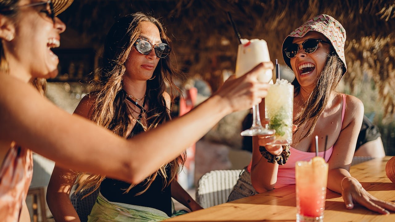 default-18 Friends at a beach bar with a woman looking concerned in the middle.
