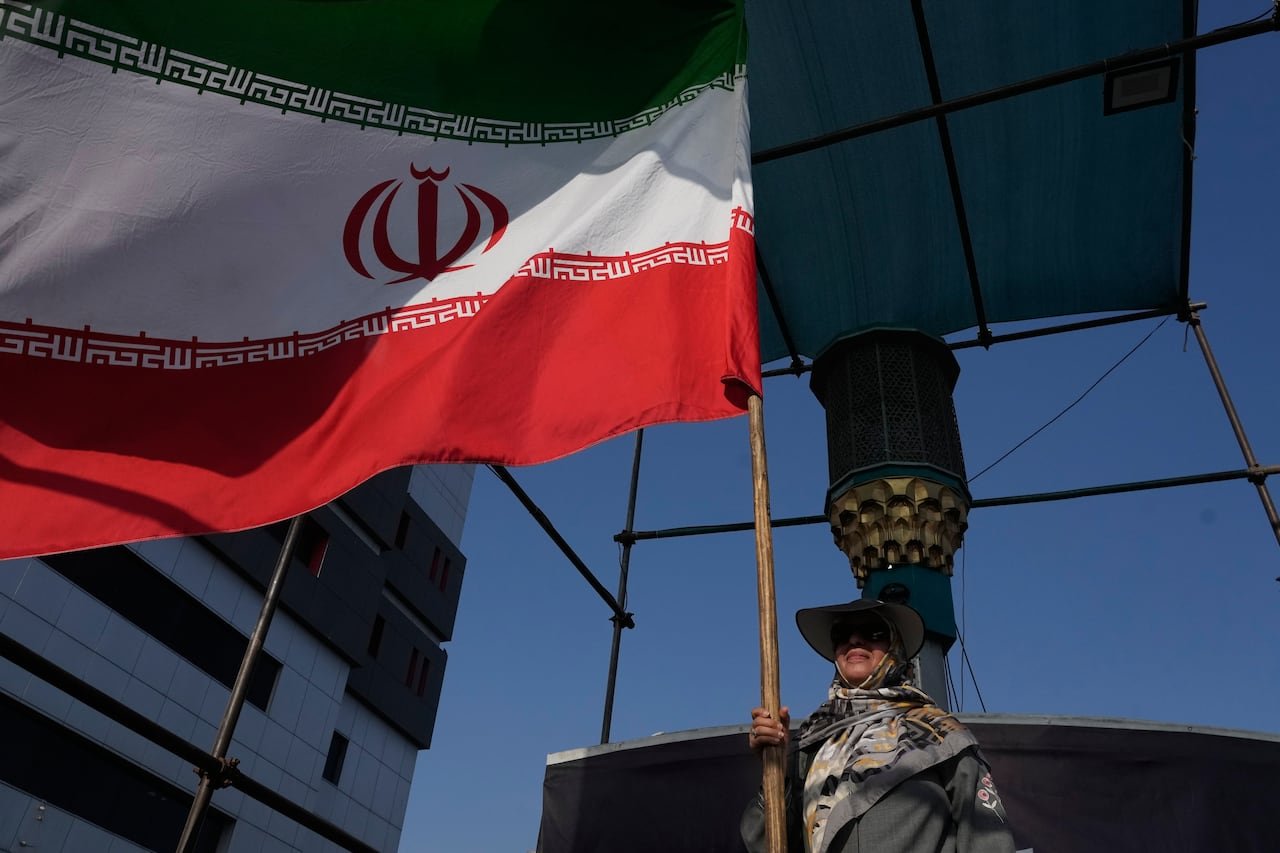 default-28 A woman holds an Iranian flag in Tehran.